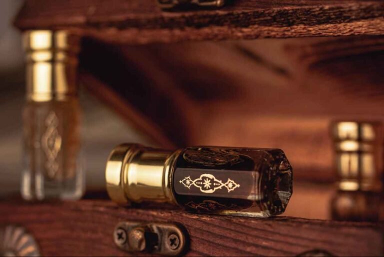Luxury oud perfume bottles displayed on a wooden box for the Best Bakhoor for Kuwaiti Weddings