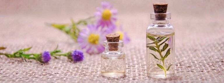 How Is Oud Oil Extracted and Made? Essential oil bottles with natural plant ingredients and flowers